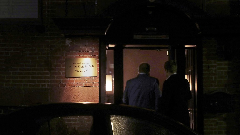 Dois clientes são vistos através entrada pouco iluminada do Wink & Nod, um bar no estilo dos ilegais da época da Proibição, em Boston, em 10 de dezembro de 2019 — Foto: AP Photo/Charles Krupa