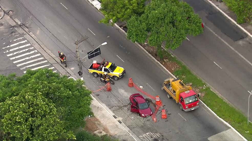 Carro cai em buraco na Avenida Itaquera — Foto: Reprodução/TV Globo