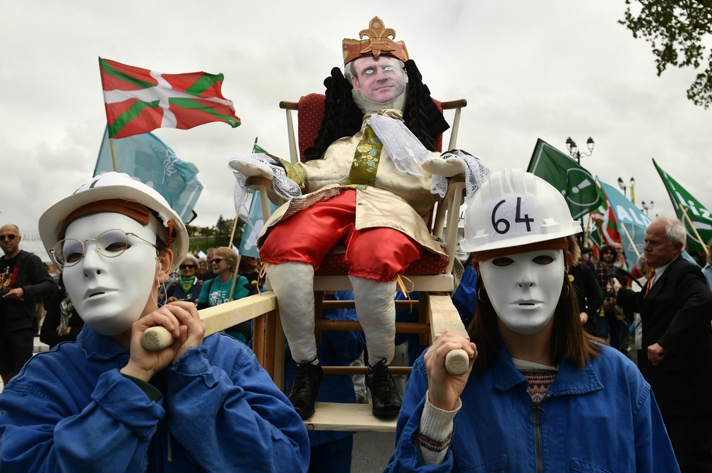 Manifestantes mascarados carregam um boneco que representa o presidente francês em Bayonne, sul da França, em 1º de maio de 2023 — Foto: Gaizka Iroz/AFP