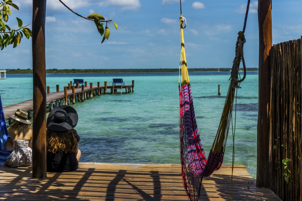 Viajantes descansam em frente à Laguna de los Siete Colores, em Bacalar, na Costa Maya, Caribe Mexicano — Foto: Ivan Macias / Wikimedia Commons / Reprodução