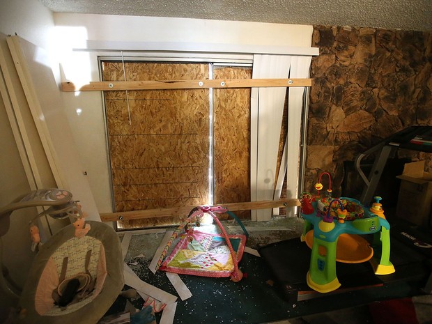 Quarto com janelas bloqueadas por tábuas de madeira na casa dos suspeitos no tiroteio de San Bernardino, Syed Farook e Tashfeen Malik, fotografado durante visita da imprensa na sexta (4) (Foto: Justin Sullivan/Getty Images/AFP)