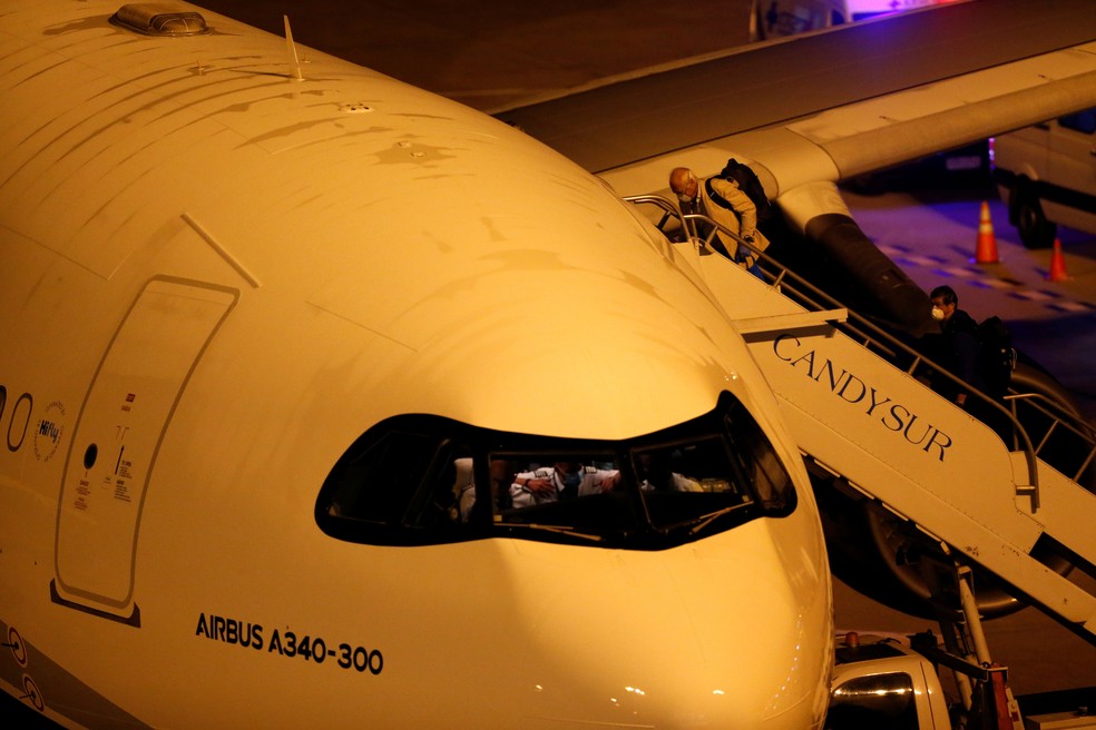 Passageiros australianos e neozelandeses que deixaram o navio de cruzeiros Greg Mortimer embarcam em uma aeronave no aeroporto de Montevidéu, no Uruguai, neste sábado (11)  — Foto: Mariana Greif/ Reuters