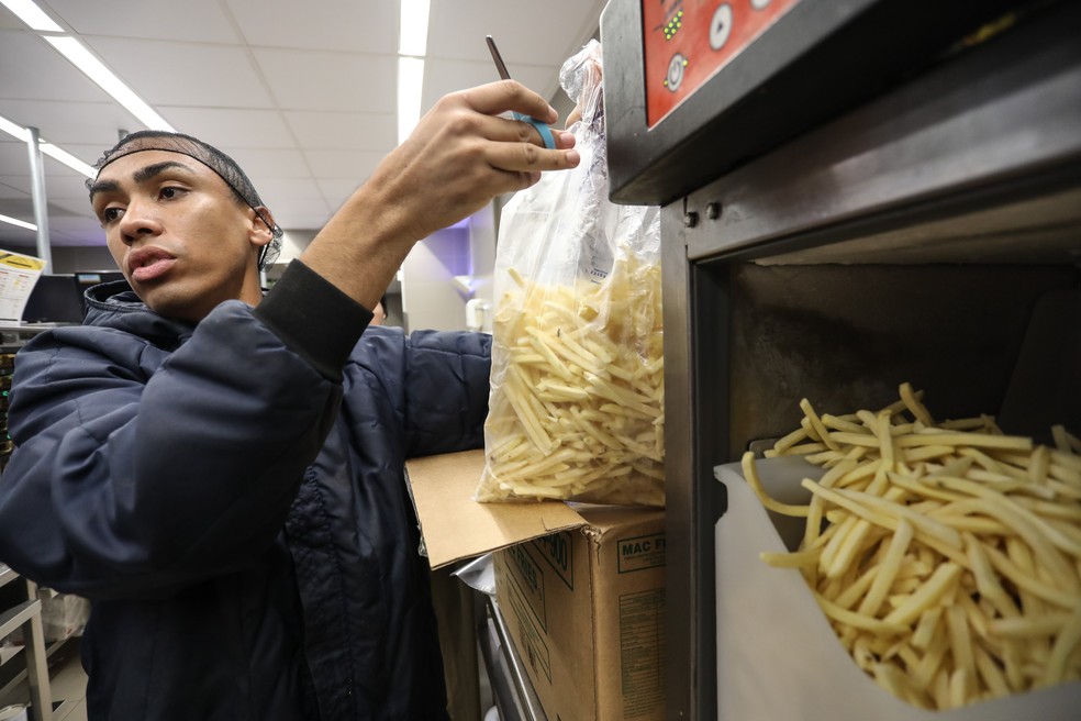 Funcionário do McDonald's despeja batata em dispensador (Foto: Fábio Tito/G1)