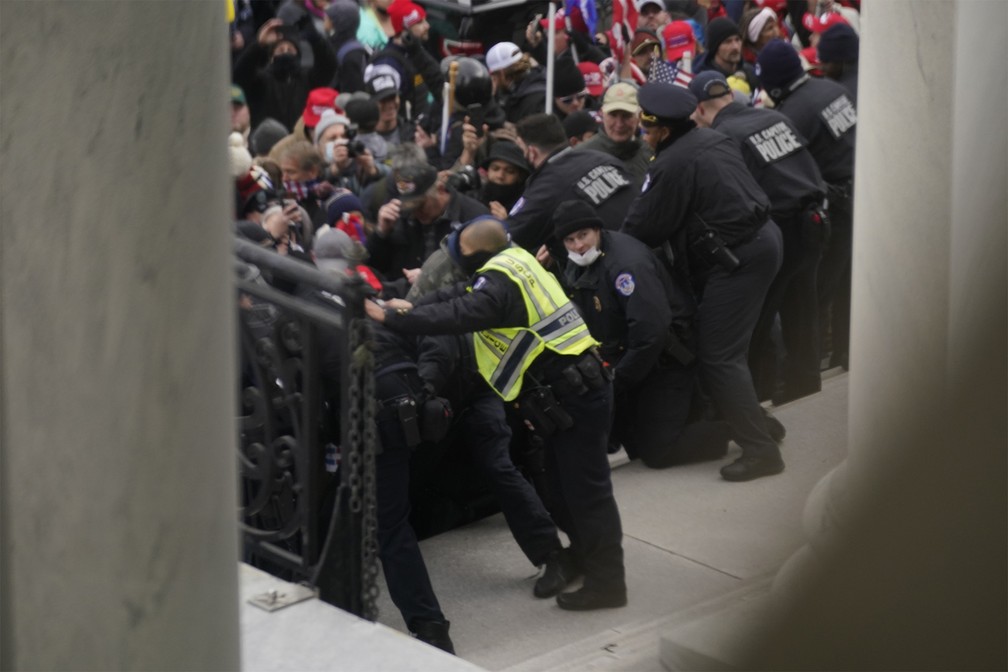 Apoiadores de Trump forçam grades em frente ao Capitólio, prédio do Congresso americano — Foto: Andrew Harnik/AP