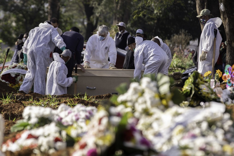 Funcionários trabalham no enterro de vítimas da Covid-19 no Cemitério Vila Formosa, zona leste de São Paulo, na manhã desta terça-feira (30), durante a pandemia do novo coronavírus no Brasil — Foto: BRUNO ROCHA/FOTOARENA/ESTADÃO CONTEÚDO