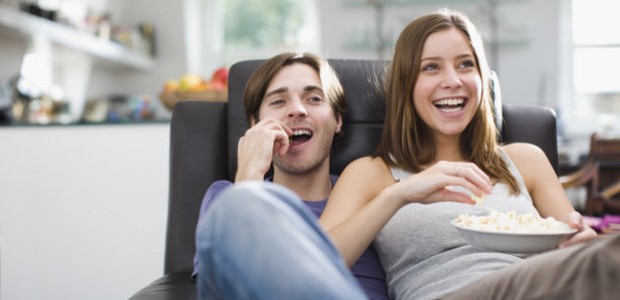 Couple watching television and eating popcorn (Foto: Getty Images/OJO Images RF)