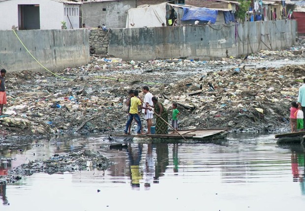 Balsa que atravessa o canal de esgoto em uma favela da Ãndia (Foto: BBC News)