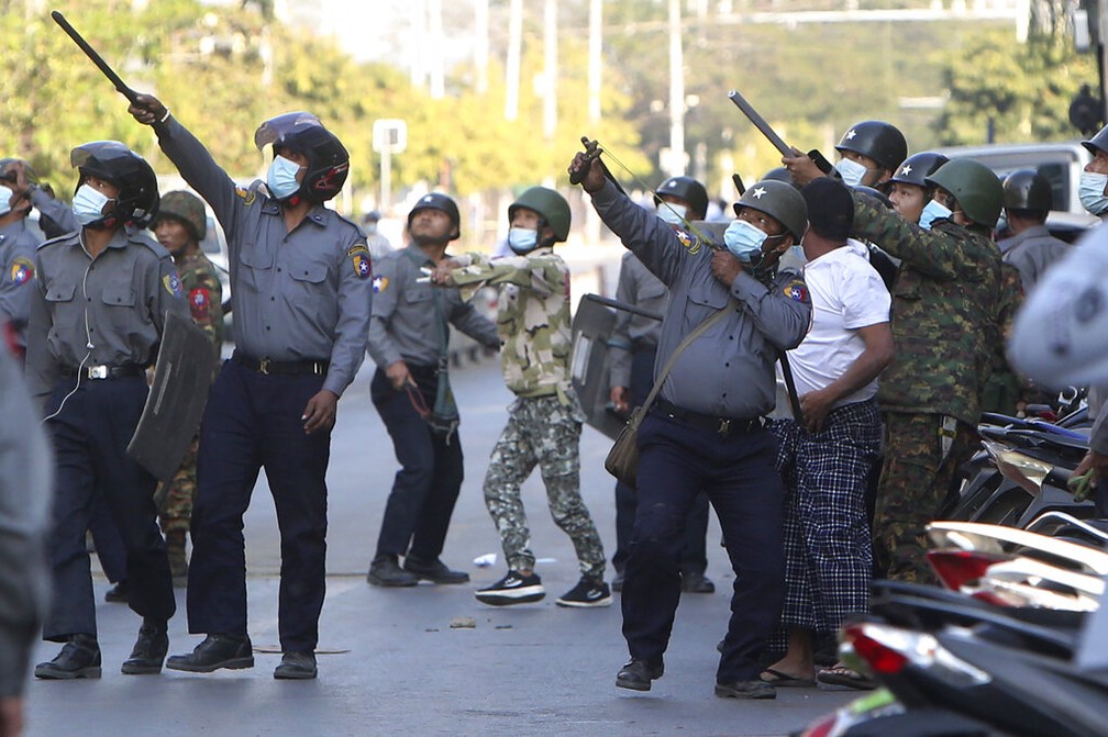 Policial usa estilingue para combater manifestantes em Mandalay, em Mianmar, nesta segunda-feira (15) — Foto: AP Photo