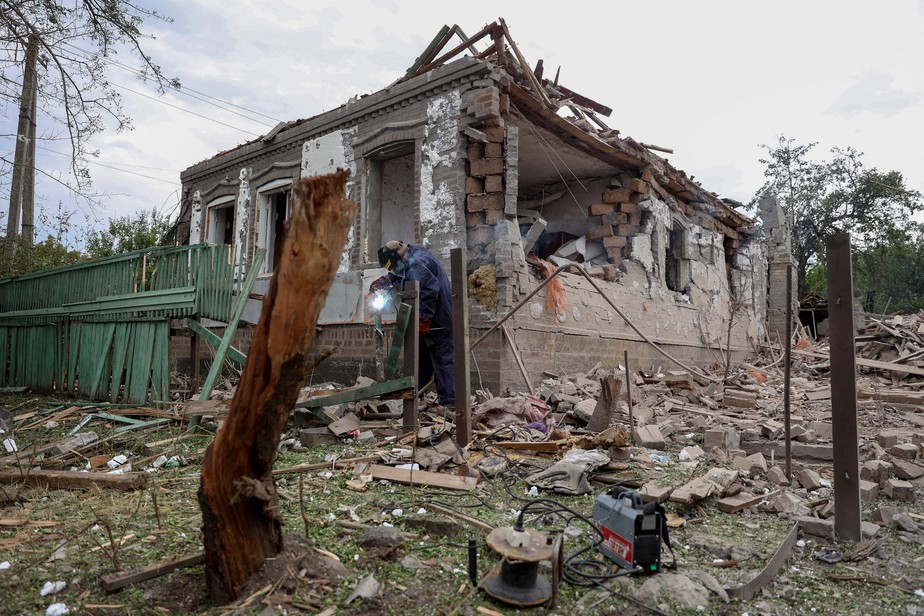 Homem restaura uma tubulação de gás perto de casa destruída em Kramatorsk, na região de Donetsk (Leste ucraniano