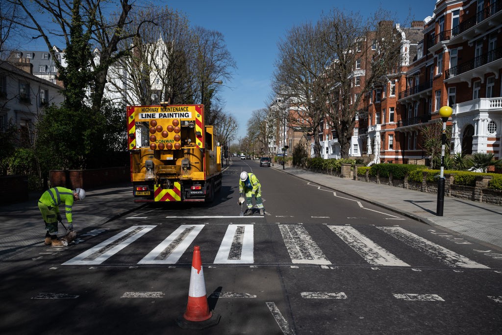 Funcionários repintam a faixa de pedestre na Abbey Road, em Londres (Foto: Getty Images)