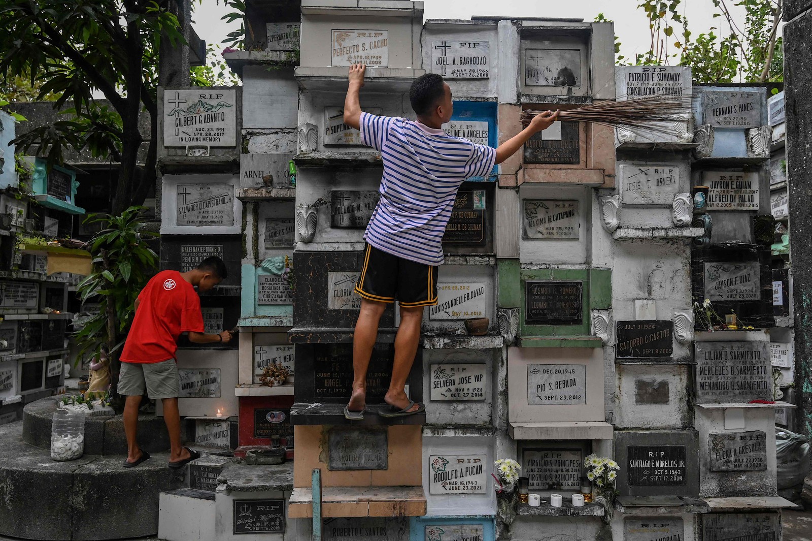 Homens limpam um cemitério em Manila, Filipinas, como preparativos do Dia de Todos os Santos em 1º de novembro — Foto: JAM STA ROSA/AFP