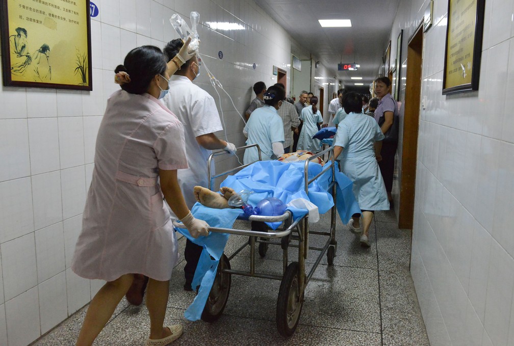 MÃ©dicos e enfermeiros transportam para atendimento ferido em atropelamento em Hengdong, na China â€” Foto: STR/ AFP