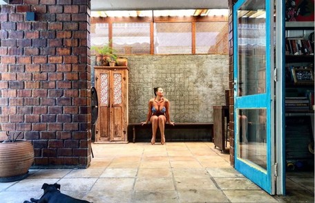 Fabiula Nascimento posa na varanda com um de seus cachorros em primeiro plano Reprodução/Instagram