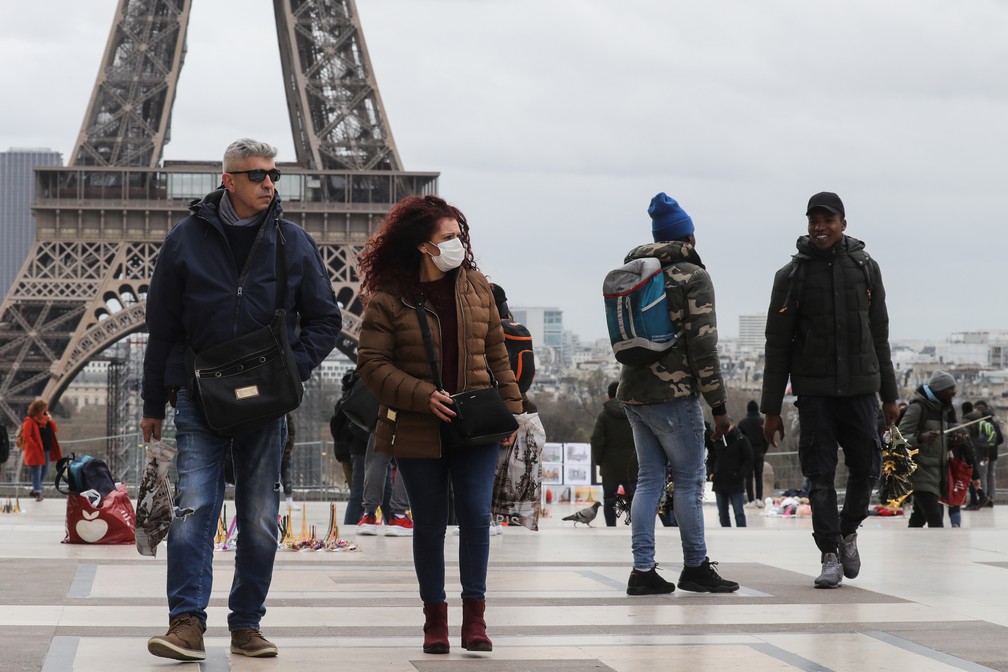 Pessoa caminham perto da Torre Eiffel nesta quinta-feira (12) — Foto: Ludovic Marin/AFP