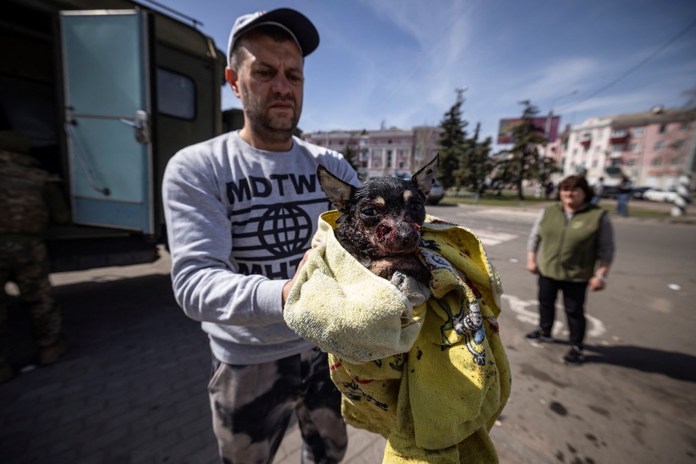 Homem carrega cachorro ferido em ataque a esta&ccedil;&atilde;o de trem em Kramatorsk, leste da Ucr&acirc;nia, em 8 de abril de 2022 &mdash; Foto: Fadel Senna/AFP