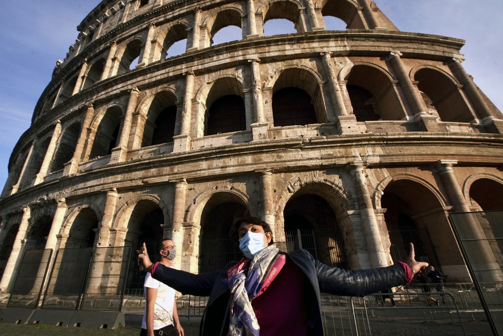 Guia turística usa máscara enquanto fala em frente do Coliseu em Roma, na Itália, durante a pandemia do novo coronavírus — Foto: Andrew Medichini/AP