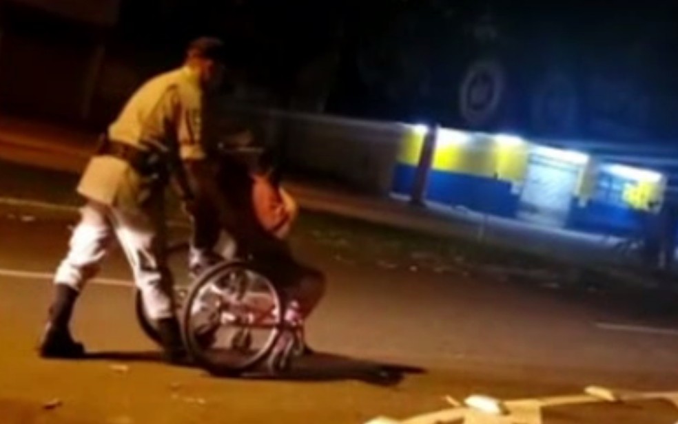 Policial militar ajuda cadeirante a chegar em casa, em Aparecida de Goiânia — Foto: Reprodução/TV Anhanguera