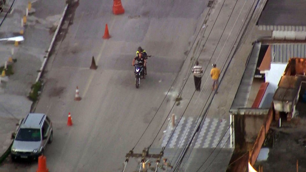 Guarupa de moto aponta fuzil para pedestres no Chapadão — Foto: Reprodução/TV Globo