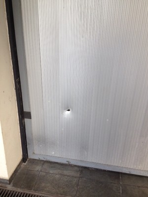 Furo no portão da garagem do Instituto Lula após ataque à bomba (Foto: Kleber Tomaz/G1)