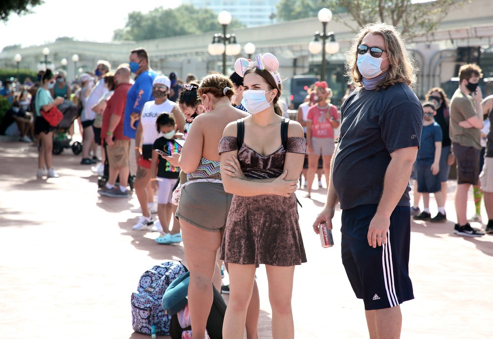 11 de julho - Visitantes com máscaras protetoras esperam do lado de fora do parque temático Magic Kingdom, no Walt Disney World, no primeiro dia de reabertura, em Orlando, na Flórida  — Foto: Gregg Newton/AFP