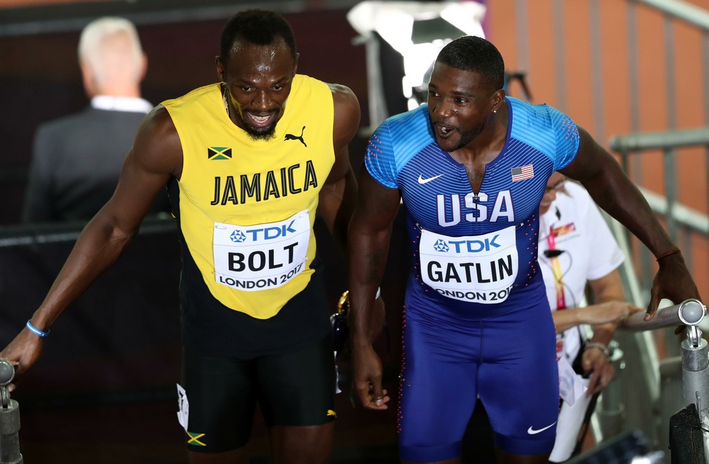 Usain Bolt e Justin Gatlin se encontram após vencerem suas respectivas baterias nas eliminatórias (Foto: Reuters)