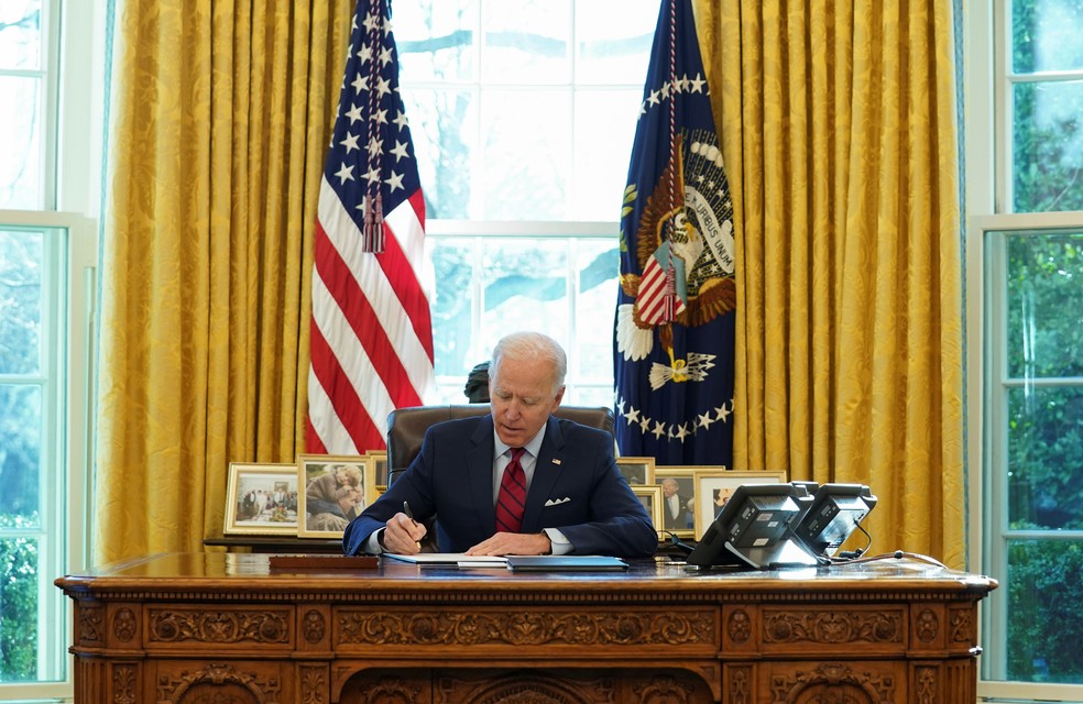 Joe Biden, presidente dos EUA, assina decretos na Casa Branca nesta quinta-feira (28) — Foto: Kevin Lamarque/Reuters
