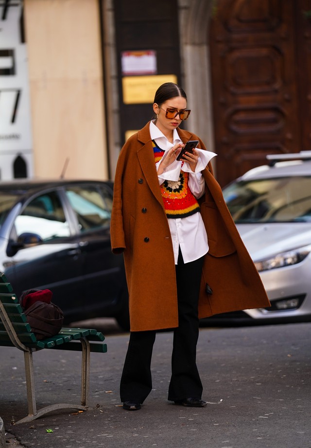 MILAN, ITALY - FEBRUARY 23: A guest wears sunglasses, a brown coat, a white long shirt, a multicolor pullover with printed patterns,, flared pants, during Milan Fashion Week Fall/Winter 2020-2021 on February 23, 2020 in Milan, Italy. (Photo by Edward Bert (Foto: WireImage)