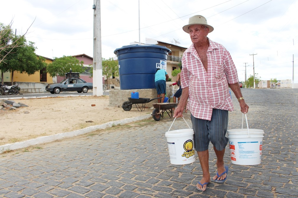 Aposentado, José Ferreira de Medeiros precisa fazer muito esforço para passar o dia inteiro levando baldes de água para casa (Foto: Anderson Barbosa/G1)