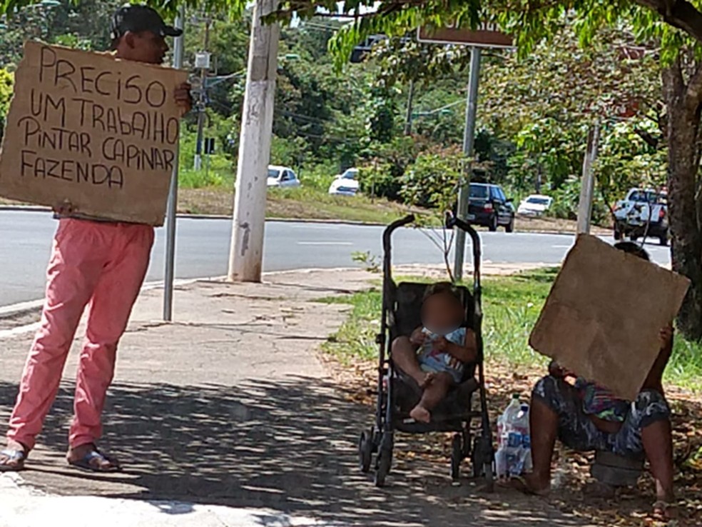 Imagem de abril mostra venezuelano pedindo emprego com cartazes em avenida de Cuiabá — Foto: Arquivo pessoal