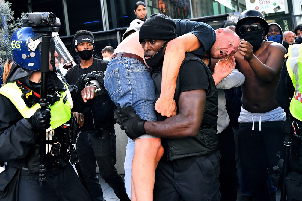 O manifestante Patrick Hutchinson carrega um suposto manifestante de extrema direita que foi ferido para um local seguro, perto da estação de Waterloo, em Londres, em 13 de junho, durante um protesto do Black Lives Matter após a morte de George Floyd na custódia policial de Minneapolis — Foto: Dylan Martinez/Reuters