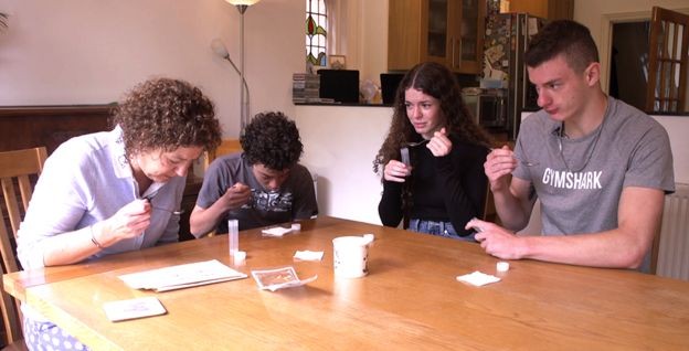 BBC: Jayne e seus três filhos adolescentes, Sam, Meg e Billy, cuspindo em uma colher para realizar teste de coronavírus (Foto: VIA BBC)