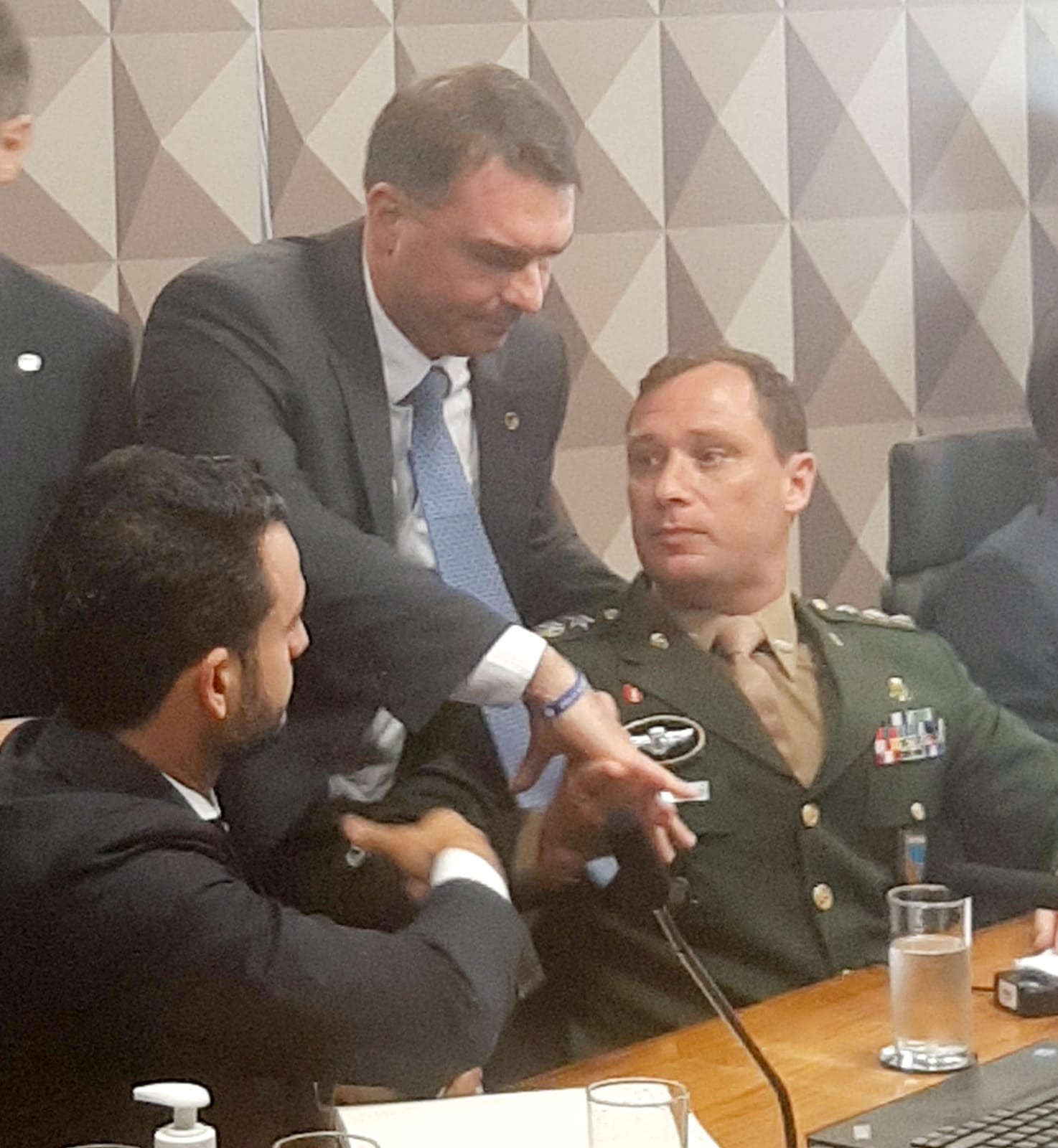 O senador Flávio Bolsonaro cumprimenta Mauro Cid na CPI do 8 de janeiro  — Foto: Reprodução 