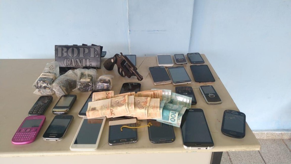 Arma, celulares e dinheiro foram apreendidos em operação nos bairros do Jacintinho e Feitosa, em Maceió — Foto: SSP