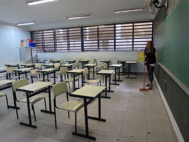 Aluna varre sala de aula usada durante a ocupação na Escola Estadual Brigadeiro Gavião Peixoto (Foto: Werther Santana/Estadão Conteúdo)