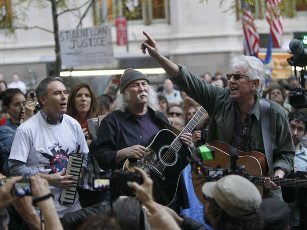 O cantor David Crosby (ao centro), canta com manifestantes do movimento "Ocupe Wall Street" na praça Zucotti, em Nova York — Foto: Mary Altaffer / AP