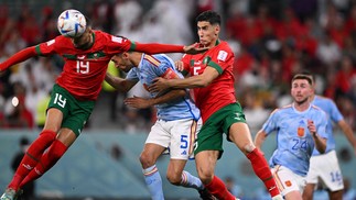 Youssef En-Nesyri disputa bola com Sergio Busquets, que é agarrado por Aguerd  — Foto: KIRILL KUDRYAVTSEV/AFP