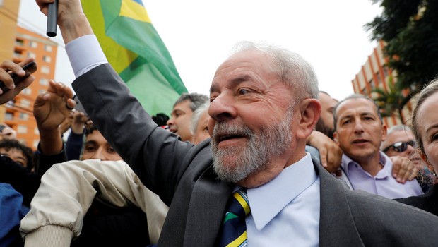 O ex-presidente Luiz Inácio Lula da Silva carrega bandeira brasileira em sua chegada ao prédio da Justiça Federal em Curitiba (Foto: Nacho Doce/Reuters)