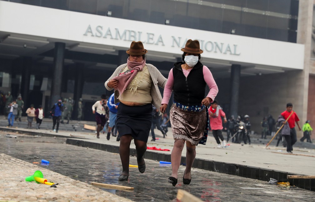 Manifestantes correm após a polícia reagir à entrada de manifestantes na Assembleia Nacional do Equador, em Quito, nesta terça (8) — Foto: Reuters/Ivan Alvarado