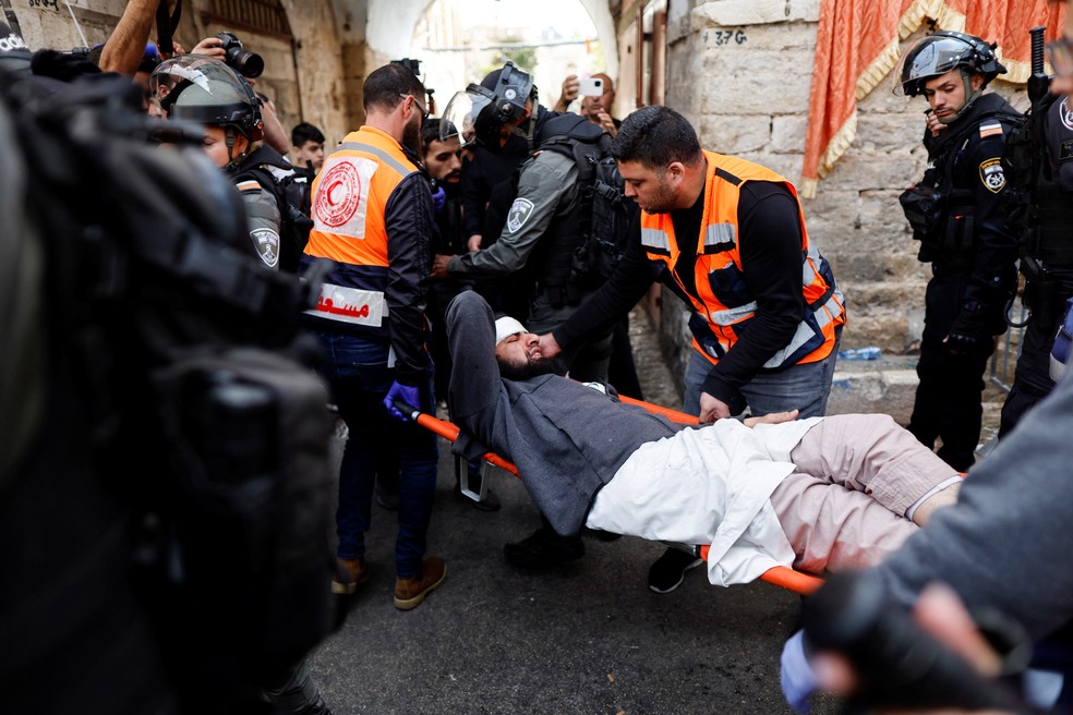 Homem ferido na Esplanada das Mesquitas neste domingo (17) é levado para hospital  — Foto: Reuters