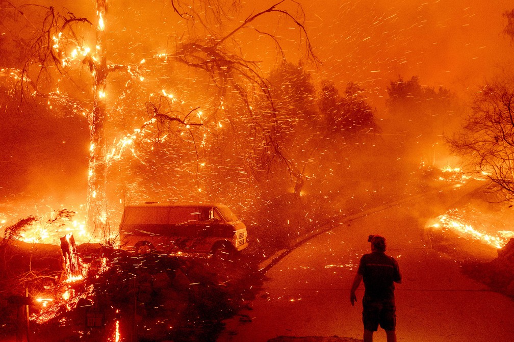 3 de dezembro - Homem observa as chamas tomando conta de sua propriedade durante incêndio apelidado de 'Bond Fire' em Orange County, na Califórnia (EUA) — Foto: Noah Berger/AP