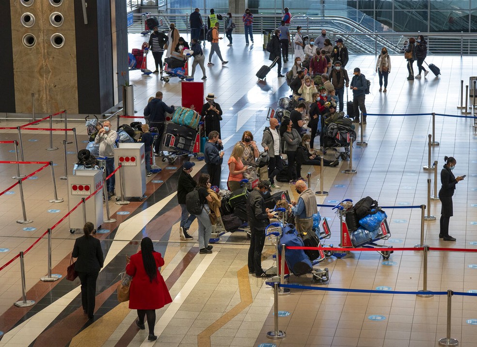 Passageiros à espera de embarque no aeroporto de Johannesburgo, na África do Sul, nesta sexta-feira (26). — Foto: AP Photo/Jerome Delay