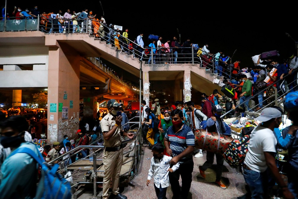 Trabalhadores em estação de ônibus em Ghaziabad, nos arredores de Nova Délhi, em 19 de abril — Foto: Adnan Abidi/Reuters