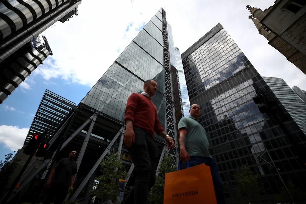 Sem m&aacute;scaras, homens caminham em ruas de Londres, no Reino Unido, nesta sexta-feira (17) &mdash; Foto: Hannah McKay/Reuters