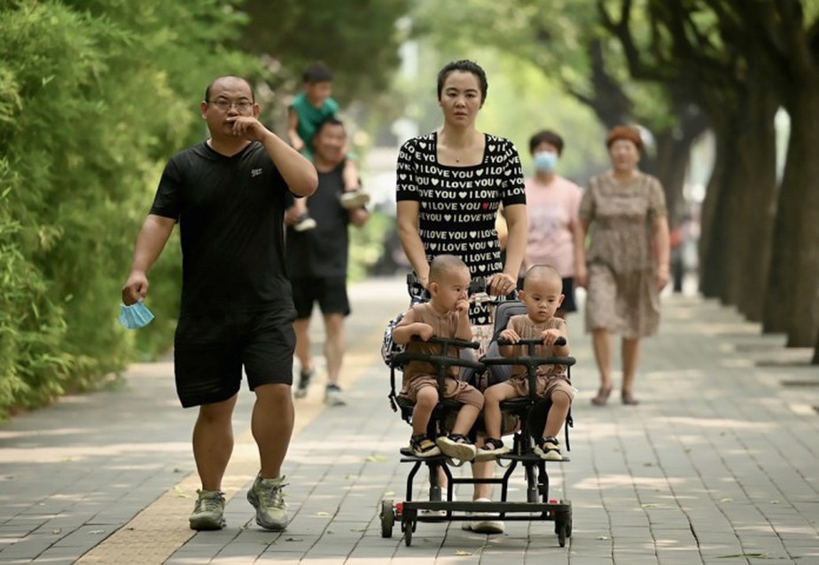 Mãe passeia com gêmeos em parque de Pequim, na China