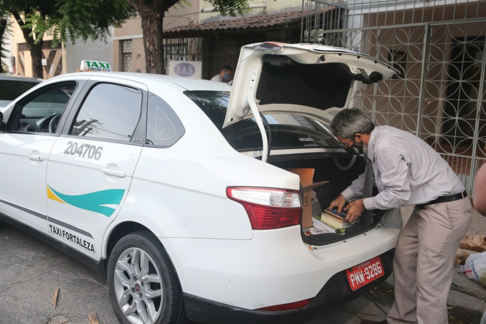Taxista cearense Francisco Carlos da Silva carrega livros no porta-malas do carro e distribui exemplares entre clientes.  — Foto: Kid Junior/SVM
