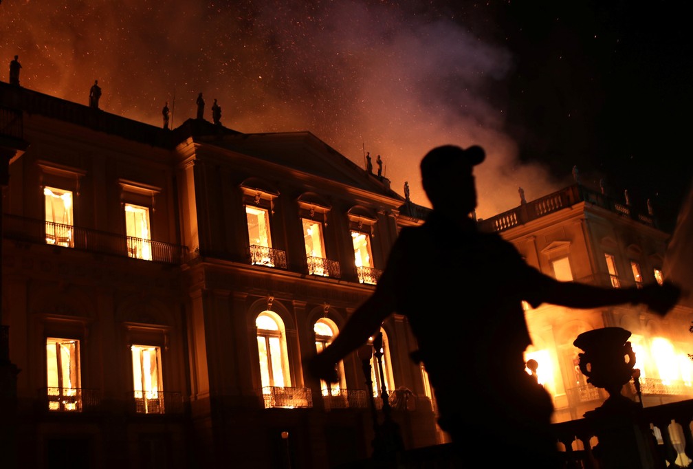 Um policial é visto durante incêndio no prédio do Museu Nacional, no Rio de Janeiro, na noite de domingo (2) — Foto: Ricardo Moraes/Reuters