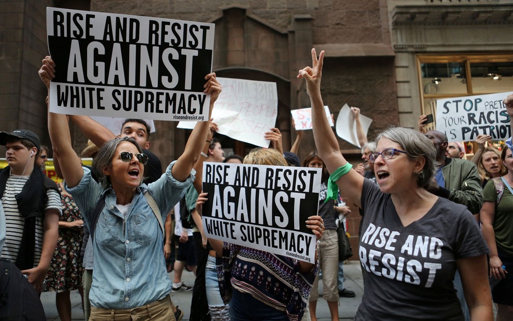 Manifestantes exibem cartazes contra o movimento de supremacistas brancos do lado de fora da Trump Tower, em Nova York, na segunda (14) (Foto: Reuters/Joe Penney)