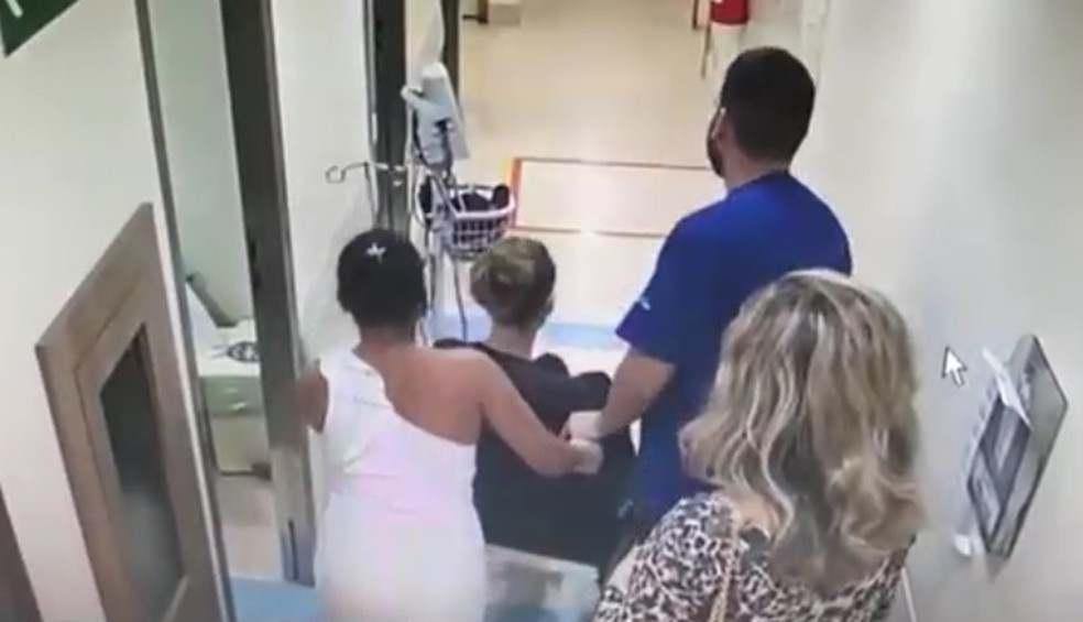 Imagem mostra Lilian Calixto chegando de cadeira de roda ao hospital Barra D'or  (Foto: ReproduÃ§Ã£o/TV Globo)