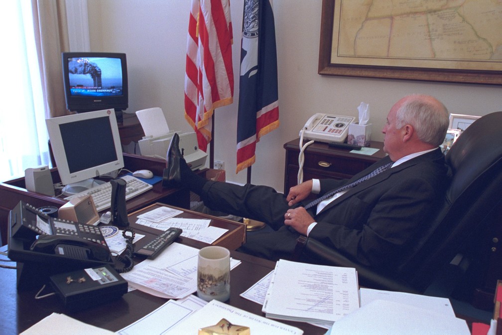 Com um pé apoiado sobre sua mesa em Washington, o então vice-presidente dos EUA, Dick Cheney, assiste à TV mostrando as torres do World Trade Center em chamas após os ataques aéreos do 11 de Setembro. A foto foi divulgada pelo governo dos EUA quase 14 anos depois, em julho de 2015 — Foto: Arquivo Nacional dos EUA via Reuters/Arquivo
