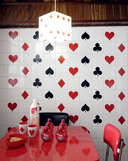 Inspirada nos anos 1950, a cozinha de azulejos brancos recebeu adesivos de naipes de cartas. A ideia surgiu pois o imóvel alugado. Casa da estilista Patricia Grejanin